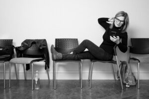 Woman seated indoors at Kamloops Skin Solutions, framed by a clean and welcoming cosmetic dermatology and vein care clinic environment.