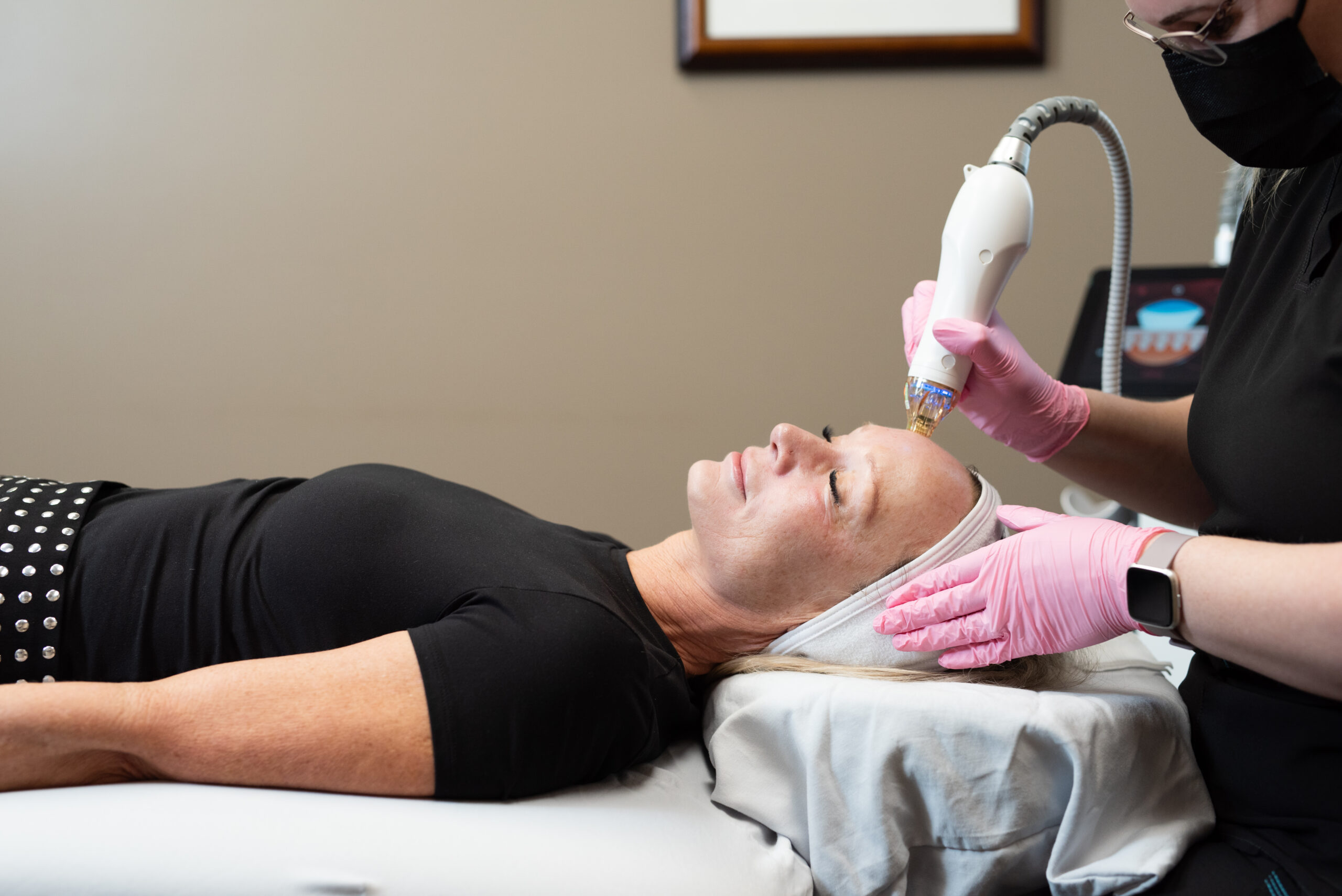 Medical aesthetic treatment being performed at Kamloops Skin Solutions using a handheld skin resurfacing device on a patient’s forehead.